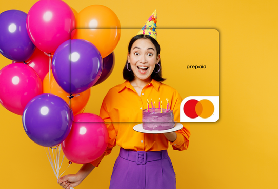 Person holding balloons and a cake with a prepaid card on a yellow background